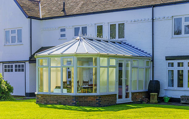 summer in a country cottage back garden with a conservatory and a lean