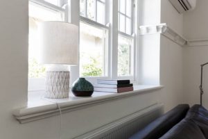 Close up details of lamp books and ornament objects on a white window sill